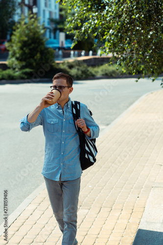 Man drinking coffee while going to work in the morning