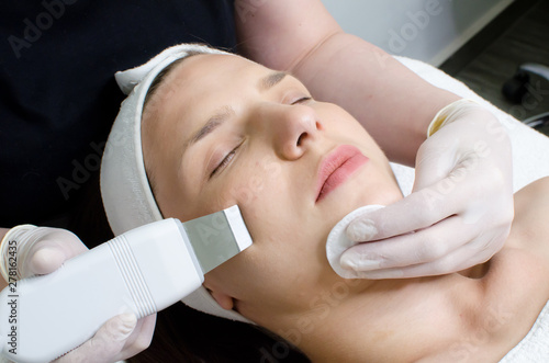 Beautiful woman receiving ultrasonic facial exfoliation procedure of ultrasonic cleaning of face in beauty salon.Modern Ultrasonic skin equipment for ultrapeel treatment 
