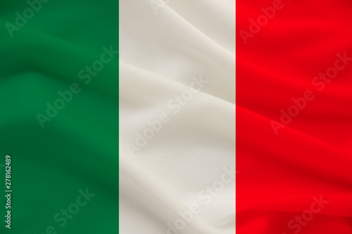 The national flag of the country of Italy on gentle silk with wind folds, travel concept, immigration, politics, copy space, close-up