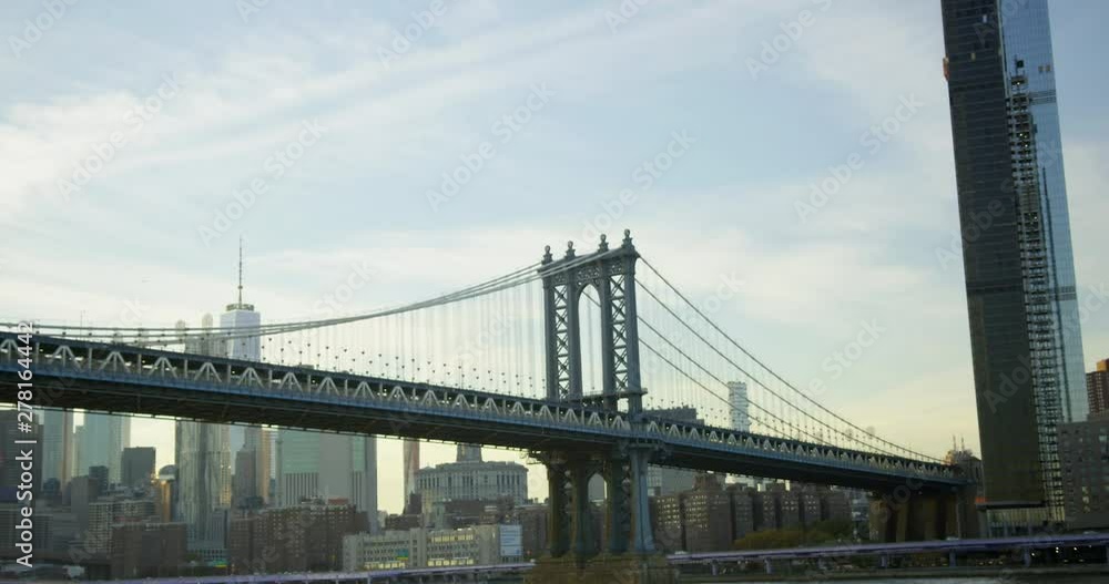 Moving Shot Away From Manhattan Bridge Travelling On Hudson River In The Sun With Beautiful New York Skyline And Impressive Skyscrapers Moving Shot Away From Manhattan Bridge Travelling On Hudson River In The Sun With Beautiful New York Skyline And Impressive Skyscrapers
