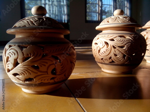 close up pottery brown color with light coming from the side on floor