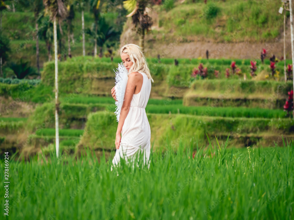 Blondie girl in straw hat and white dress on the rice fields Blondie girl in straw hat and white dress on the rice fields