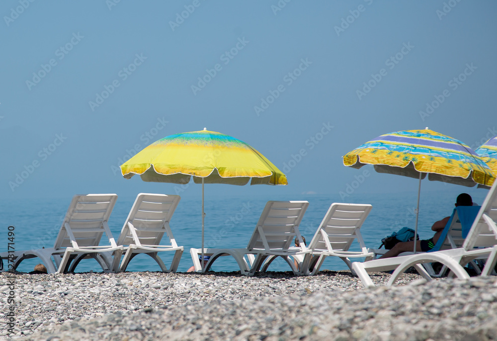beach seating, sun beds and umbrellas against the backdrop of the sea