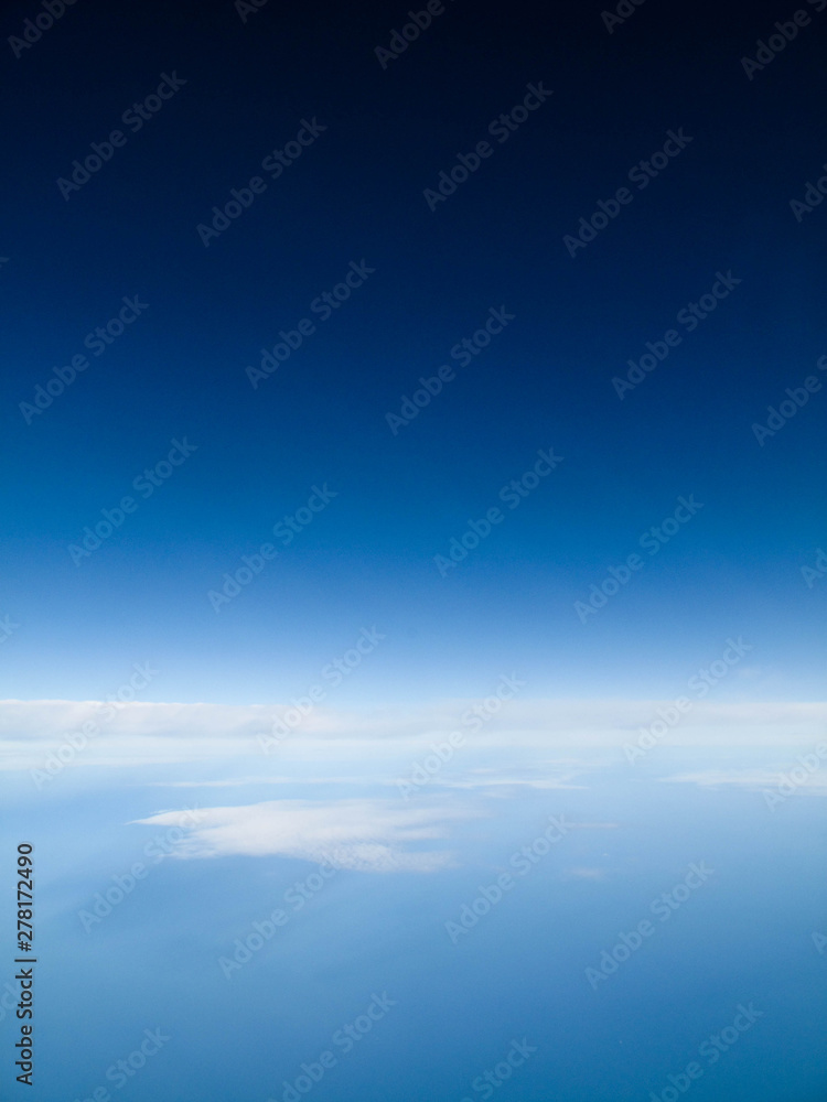 Clear blue sky with calming bed of white clouds from a flight in Spring or Summer