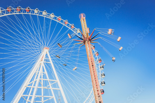 Ferris wheel and carousel with chains in an amusement park