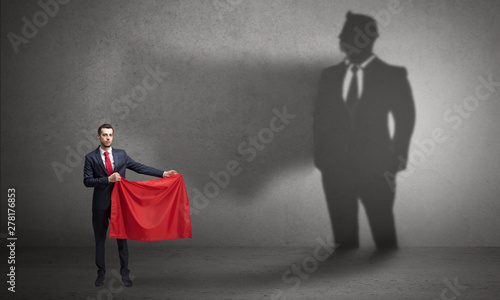 Businessman standing with red cloth on his hand and his shadow on the background