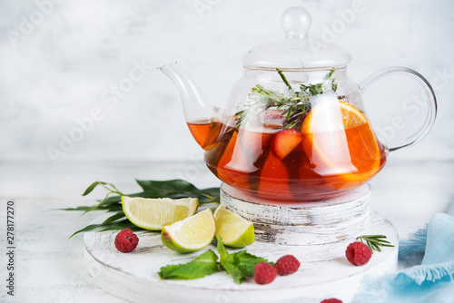 Summer tea in a kettle of fresh fruit and berries. Natural berry tea light background.