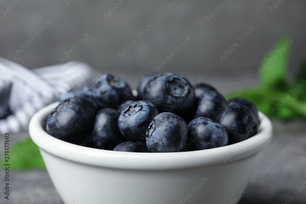 Bowl of tasty blueberries on grey table, closeup Bowl of tasty blueberries on grey table, closeup