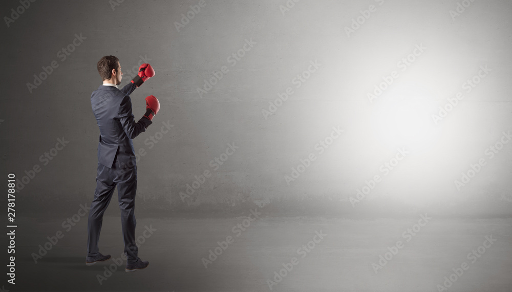 Businessman fighting with boxing gloves in an empty space Businessman fighting with boxing gloves in an empty space