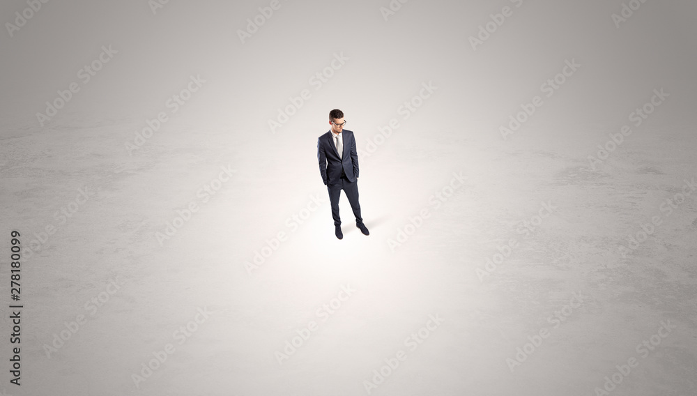 Young businessman standing alone in the middle of an empty space Young businessman standing alone in the middle of an empty space
