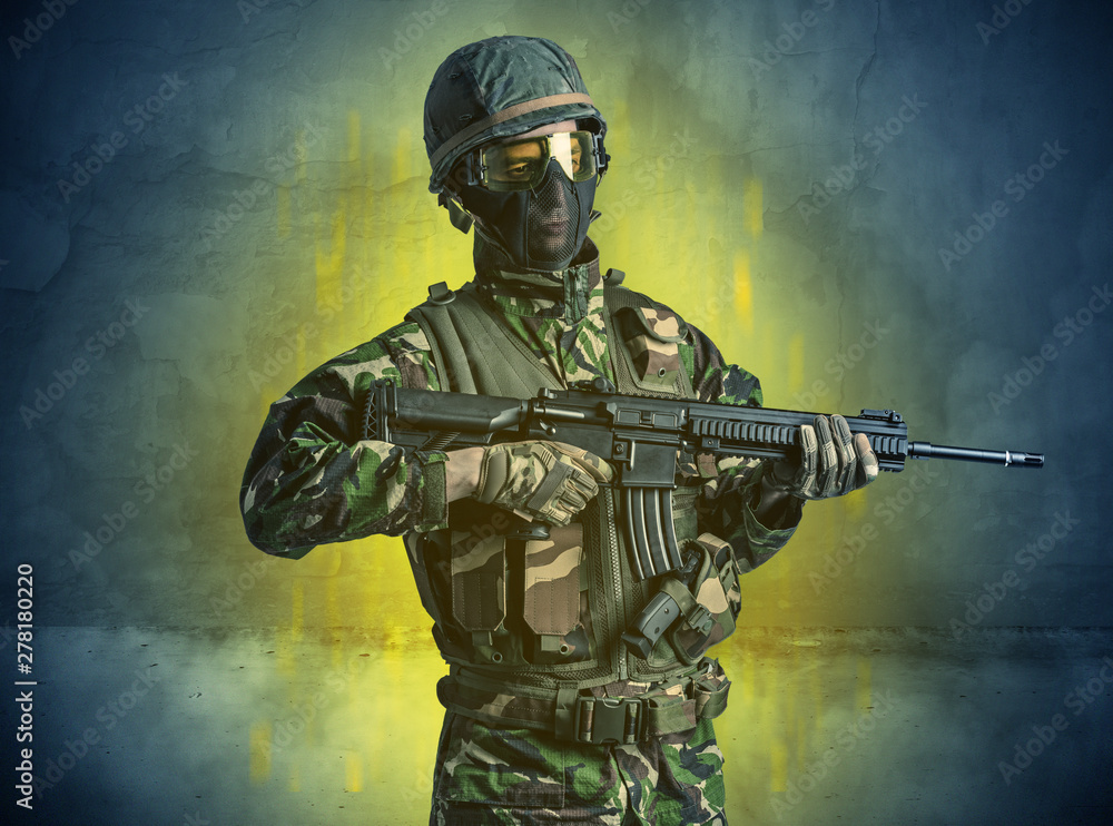 Fototapeta premium Hazard, menace soldier in a ruined crumbly building with arms on his hand