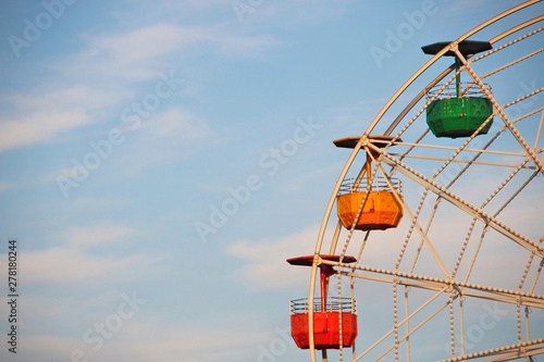Multi-colored ferris wheel in an amusement park.