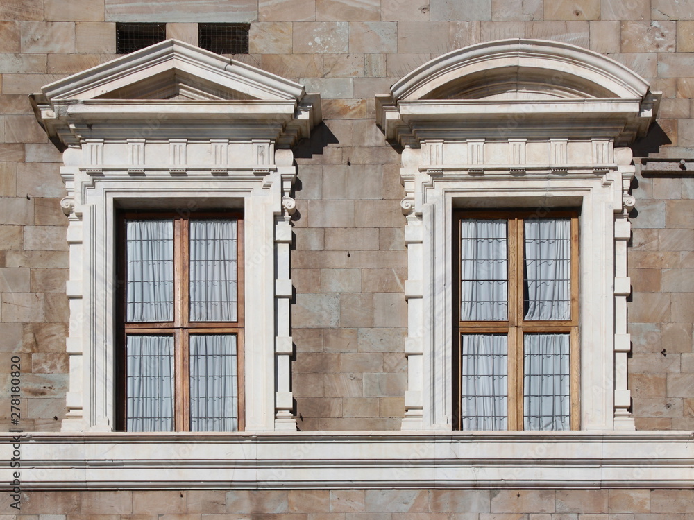 Two mannerist windows topped by a pediment at Palazzo alla Giornata in Pisa, Italy
