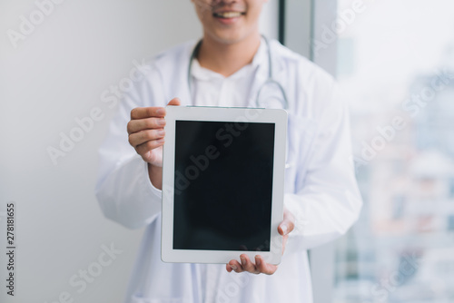 happy young doctor holding tablet