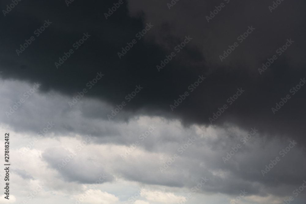 A stormy dark sky with white in the bottom, gray in the middle and black clouds on the top of the frame