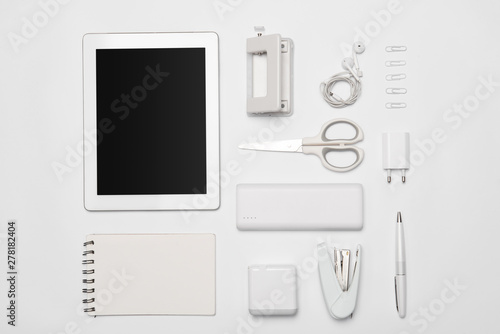 Mix of office supplies and gadgets on white background