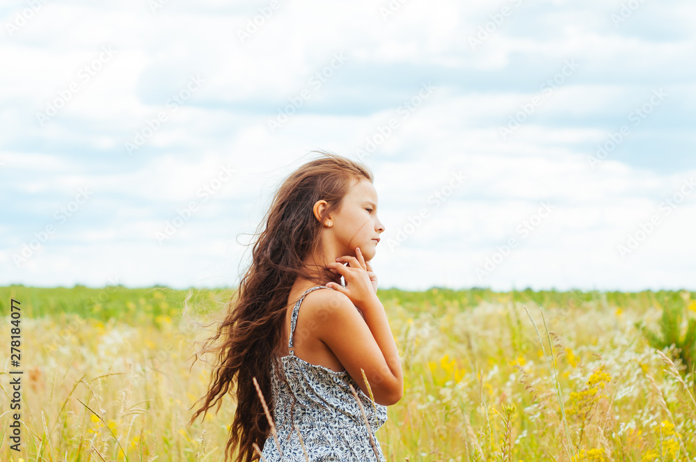 Emotional portrait of a little girl in the field enjoying the summer Emotional portrait of a little girl in the field enjoying the summer