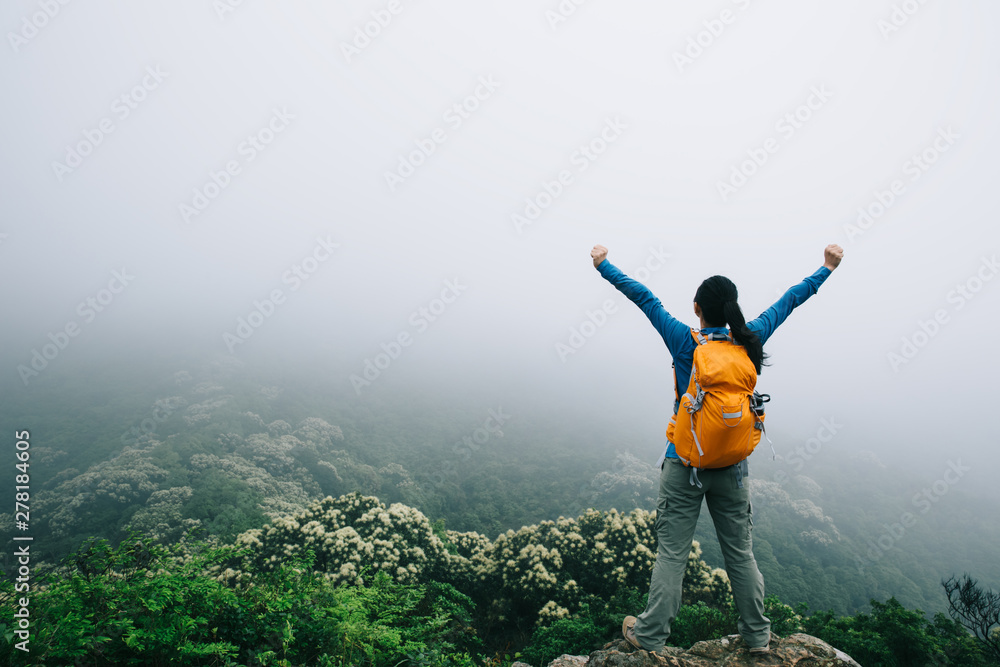 Successful young woman backpacker open arms on spring forest mountain peak Successful young woman backpacker open arms on spring forest mountain peak