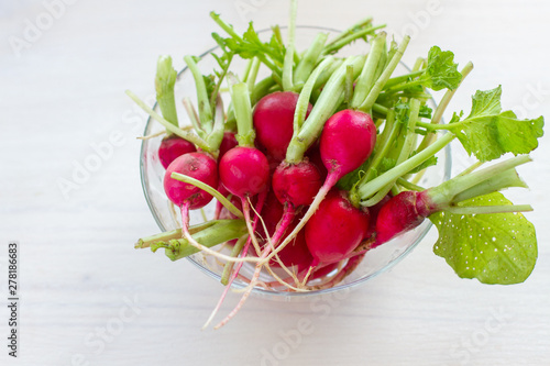 fresh radishes in a glass bowl on white background. close up