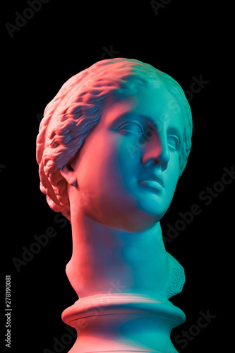 Gypsum copy of ancient statue Venus head isolated on black background. Plaster sculpture woman face. Multi color toned. photo