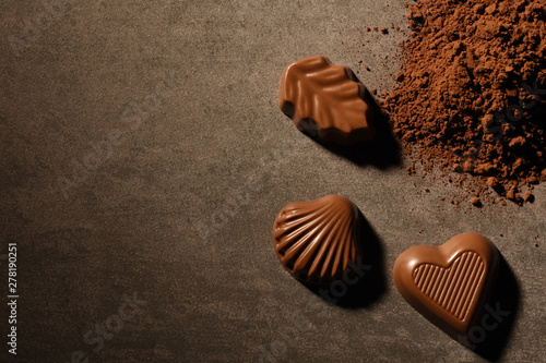 Chocolate truffles with cocoa powder on concrete background with copy space