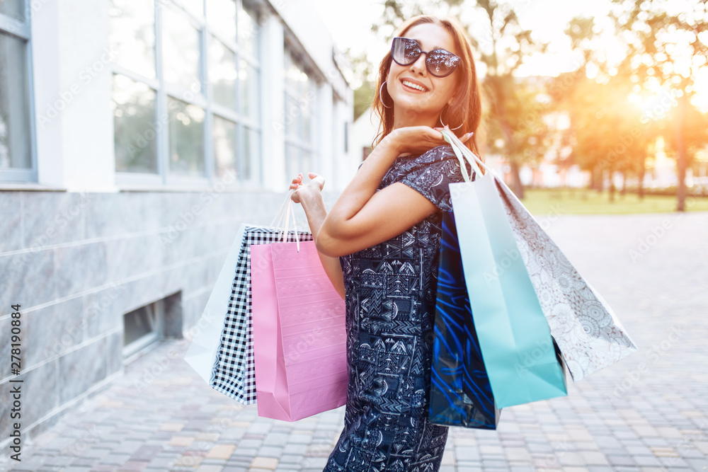 Young attractive girl enjoying a good shopping in the city , with bags in hand Young attractive girl enjoying a good shopping in the city , with bags in hand