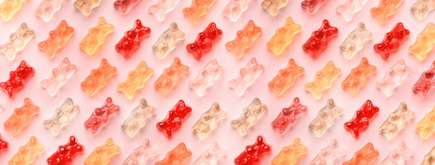 Flat lay composition with delicious jelly bears, jelly bears pattern on pink background, panoramic image