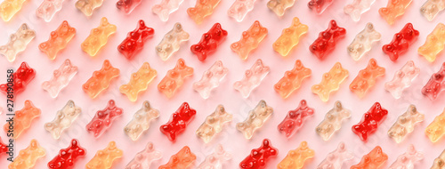 Flat lay composition with delicious jelly bears, jelly bears pattern on pink background, panoramic image photo