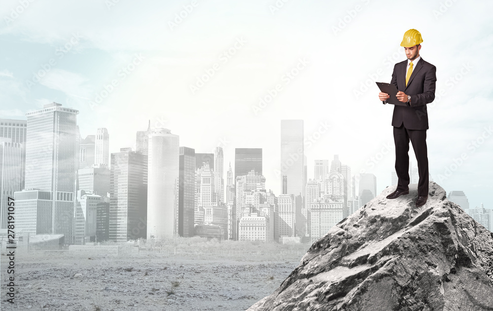 Young architect looking to ruined city from distance and thinking about investments Young architect looking to ruined city from distance and thinking about investments