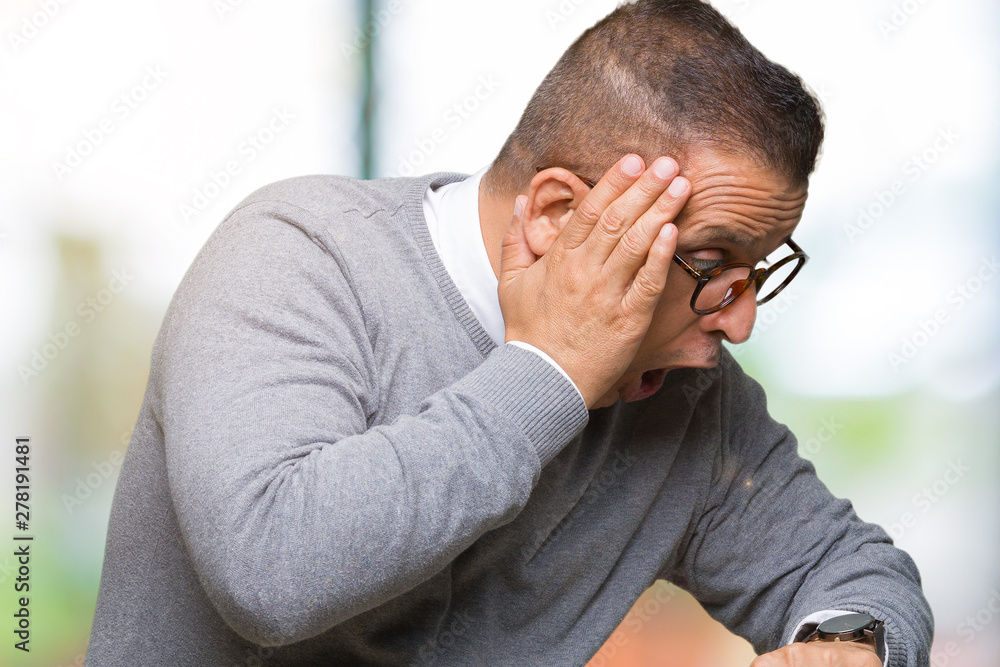 Middle age bussines arab man wearing glasses over isolated background Looking at the watch time worried, afraid of getting late Middle age bussines arab man wearing glasses over isolated background Looking at the watch time worried, afraid of getting late