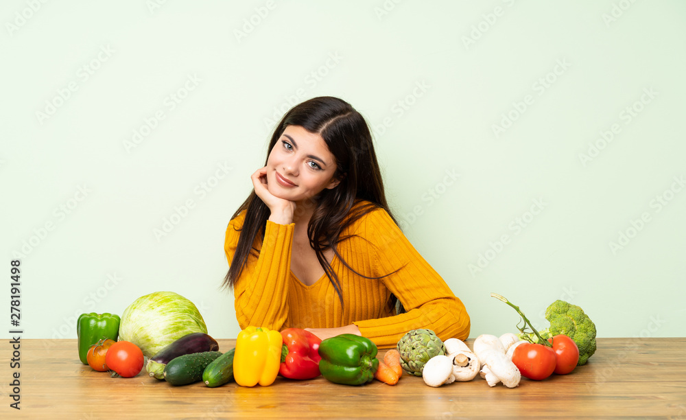 Fototapeta premium Teenager girl with many vegetables smiling