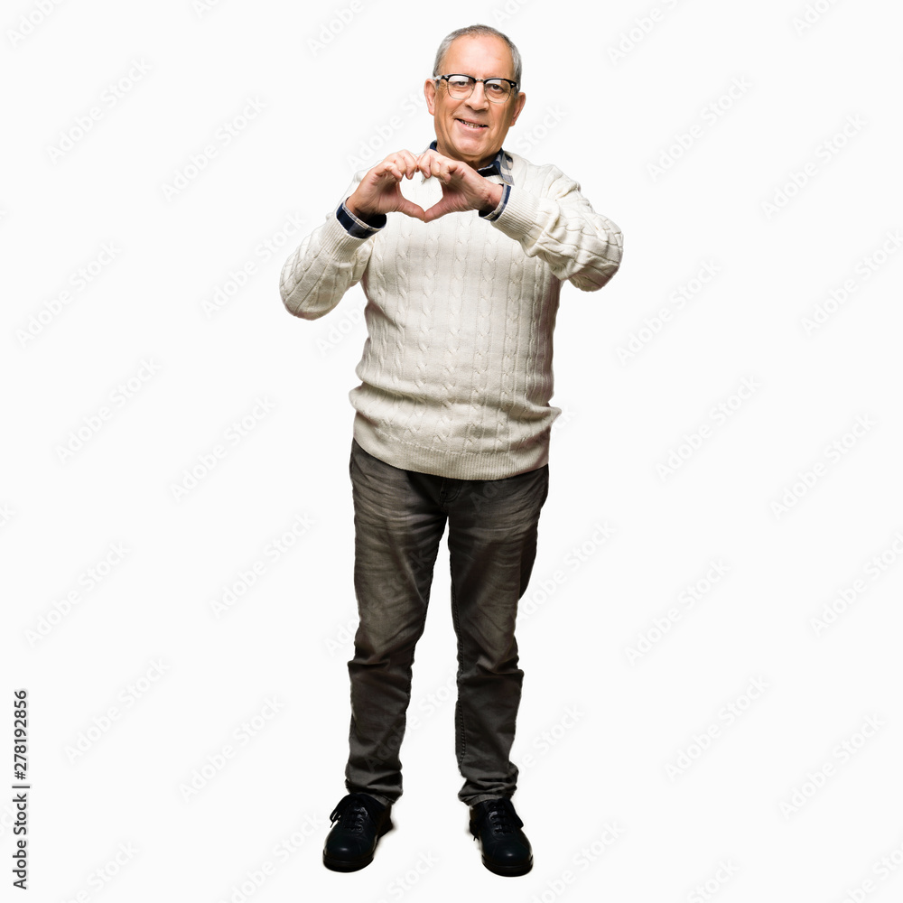 Handsome senior man wearing glasses and winter sweater smiling in love showing heart symbol and shape with hands. Romantic concept. Handsome senior man wearing glasses and winter sweater smiling in love showing heart symbol and shape with hands. Romantic concept.