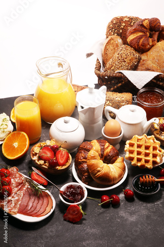 Huge healthy breakfast on table with coffee, orange juice, fruits, waffles and croissants. Good morning concept.