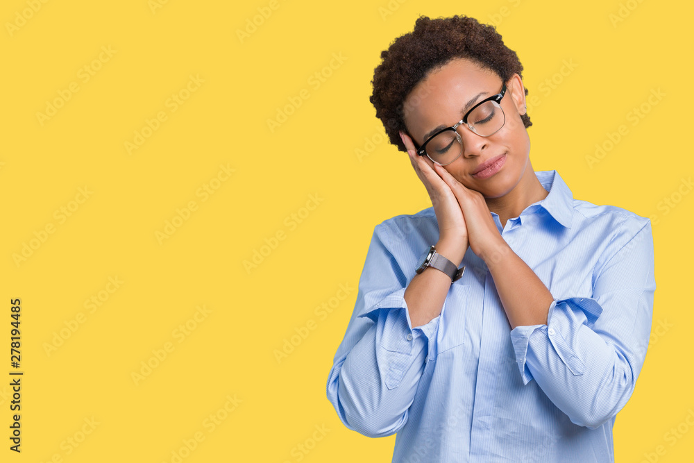 Young beautiful african american business woman over isolated background sleeping tired dreaming and posing with hands together while smiling with closed eyes. Young beautiful african american business woman over isolated background sleeping tired dreaming and posing with hands together while smiling with closed eyes.