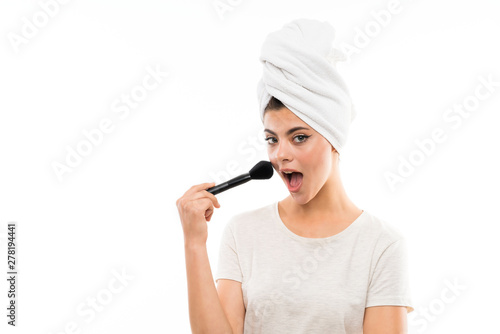 Teenager girl over isolated white background with makeup brush © luismolinero