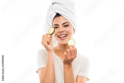 Beautiful young woman holding slices of cucumber.