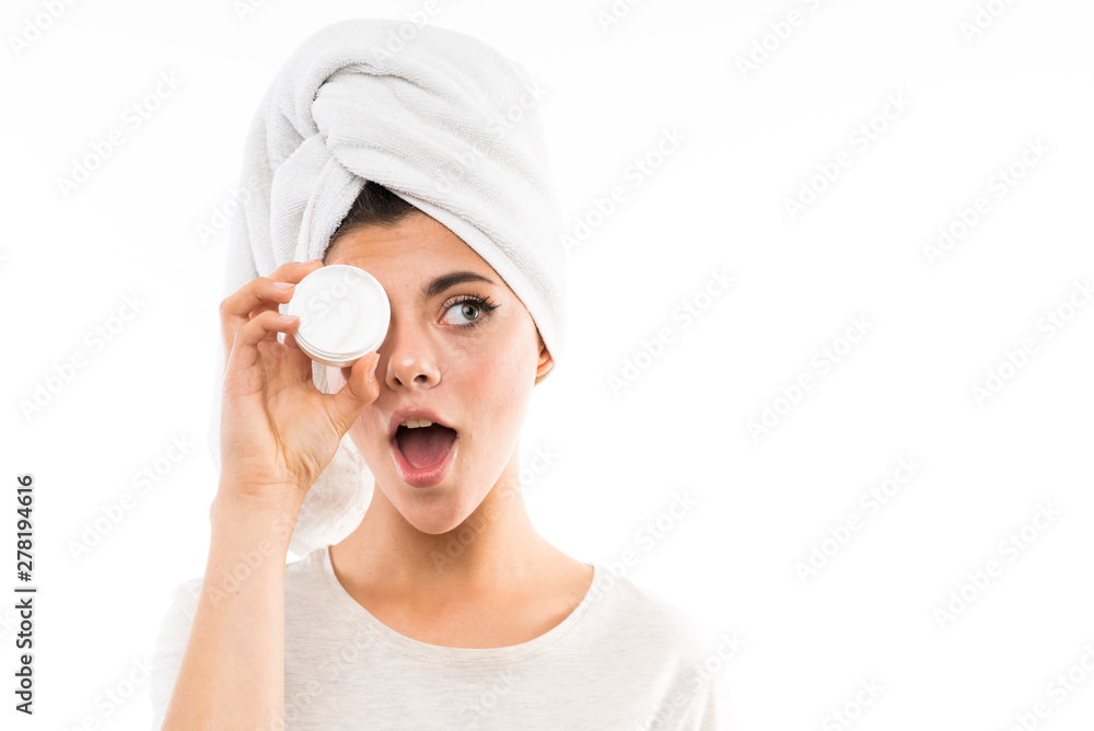 Teenager girl over isolated white background with moisturizer