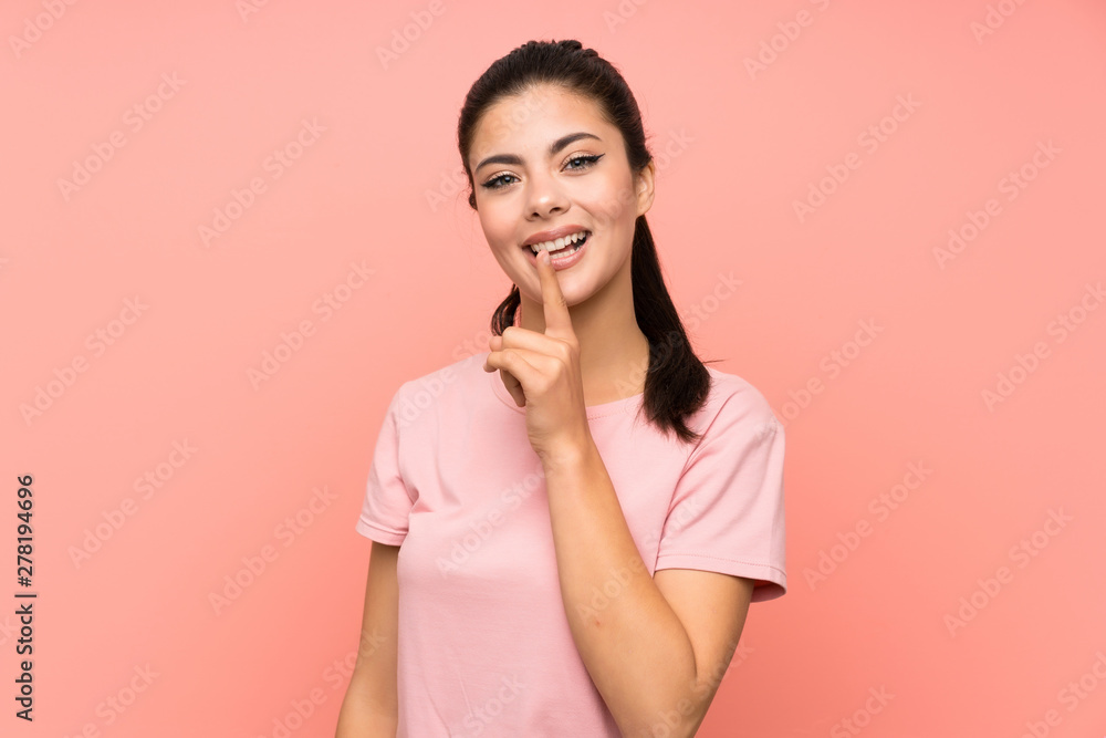 Teenager girl over isolated pink background doing silence gesture Teenager girl over isolated pink background doing silence gesture