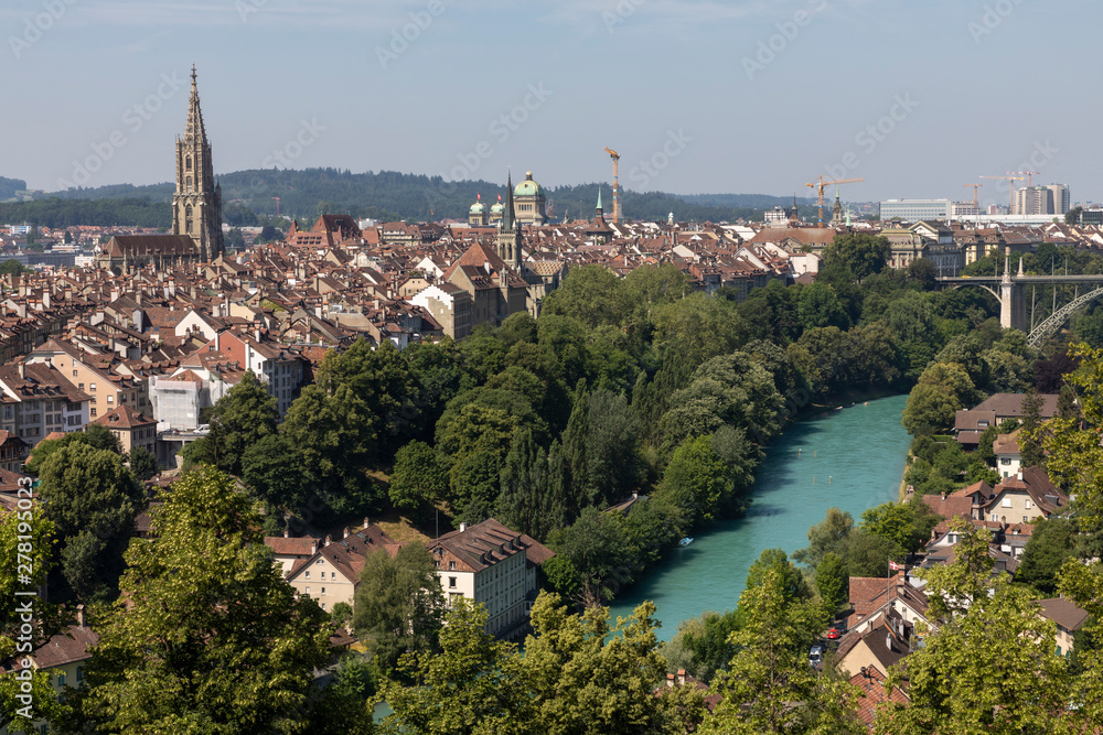 A cityscape of Bern,  view over the rooftops of the historic Old Town, the Münster (Minster) and the loop in the Aare river
