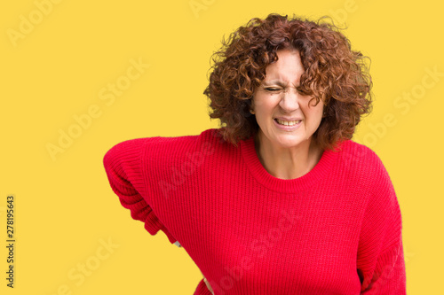 Beautiful middle ager senior woman red winter sweater over isolated background Suffering of backache, touching back with hand, muscular pain