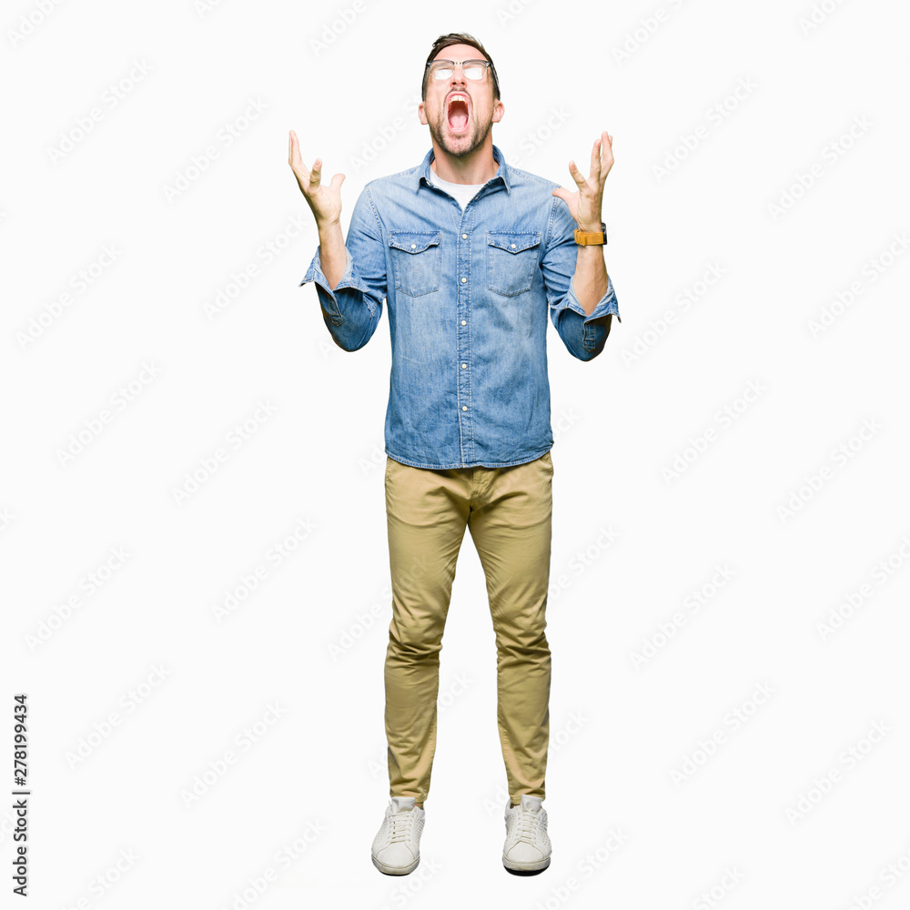 Handsome man wearing glasses crazy and mad shouting and yelling with aggressive expression and arms raised. Frustration concept. Handsome man wearing glasses crazy and mad shouting and yelling with aggressive expression and arms raised. Frustration concept.
