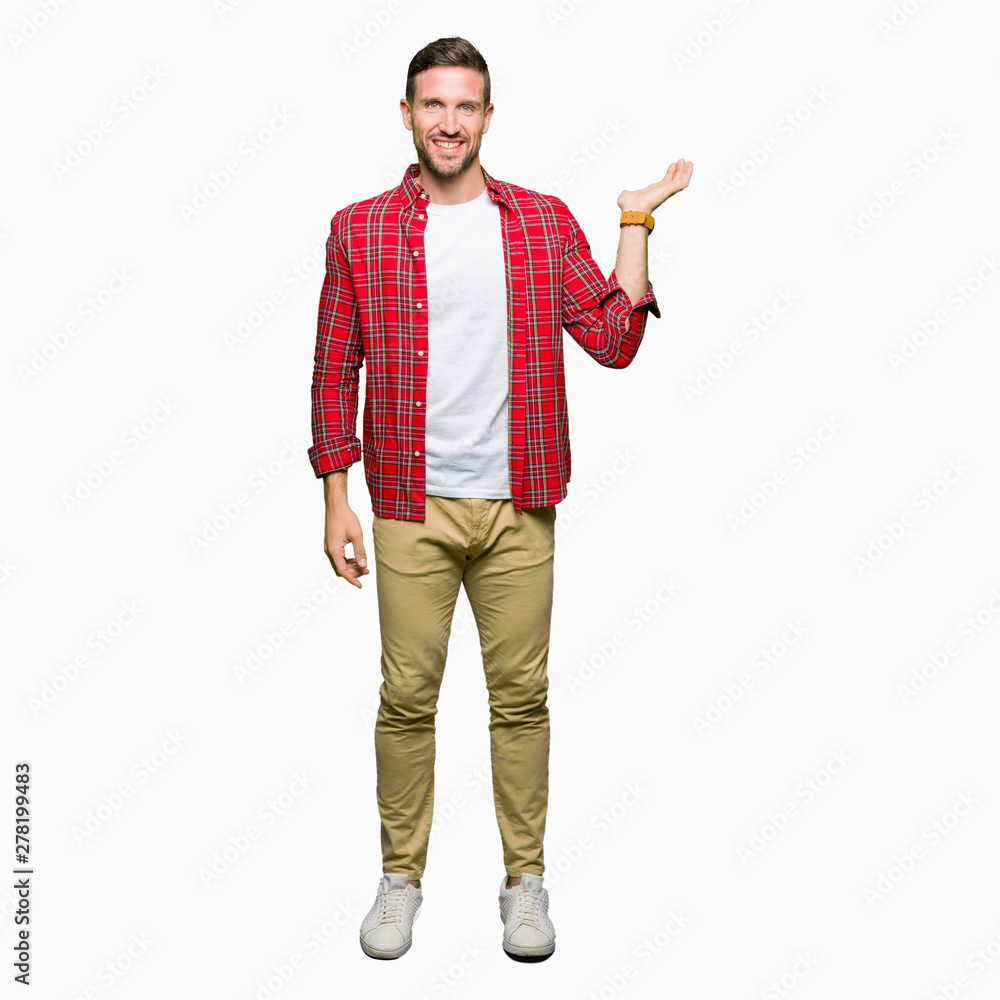 Handsome man wearing casual shirt smiling cheerful presenting and pointing with palm of hand looking at the camera. Handsome man wearing casual shirt smiling cheerful presenting and pointing with palm of hand looking at the camera.
