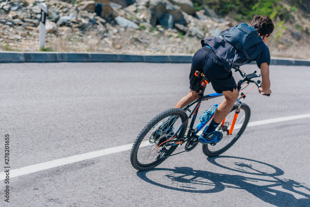 Obraz premium Fit biker riding downhill wearing biking gear on a sunny day.