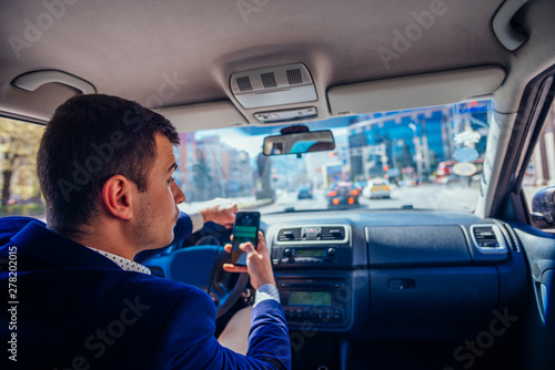 Reckless businessman driving in the city during the rush hour while talking on his phone.