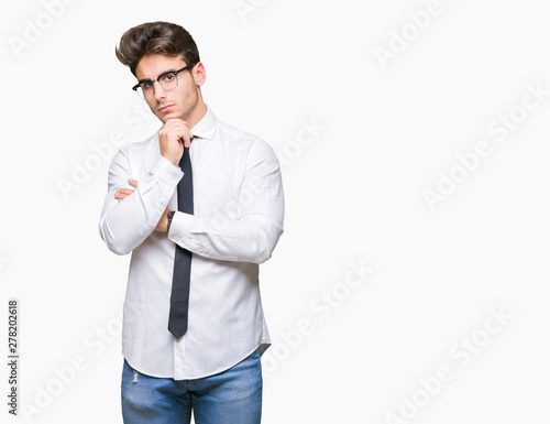 Young business man wearing glasses over isolated background with hand on chin thinking about question, pensive expression. Smiling with thoughtful face. Doubt concept. © Krakenimages.com