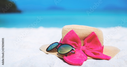 Straw hat and sun glasses on beach