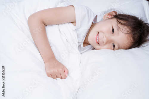 Chinese girl in white dress lying in bed