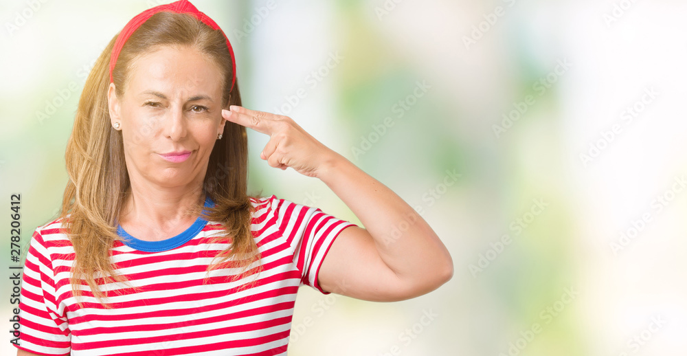 Beautiful middle age woman wearing casual stripes t-shirt over isolated background Shooting and killing oneself pointing hand and fingers to head, suicide gesture.