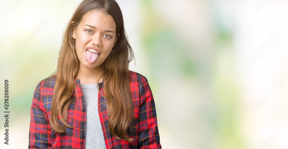 Young beautiful brunette woman wearing a jacket over isolated background sticking tongue out happy with funny expression. Emotion concept.