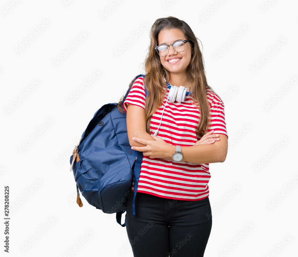 Young beautiful brunette student woman wearing headphones and backpack over isolated background happy face smiling with crossed arms looking at the camera. Positive person. Young beautiful brunette student woman wearing headphones and backpack over isolated background happy face smiling with crossed arms looking at the camera. Positive person.